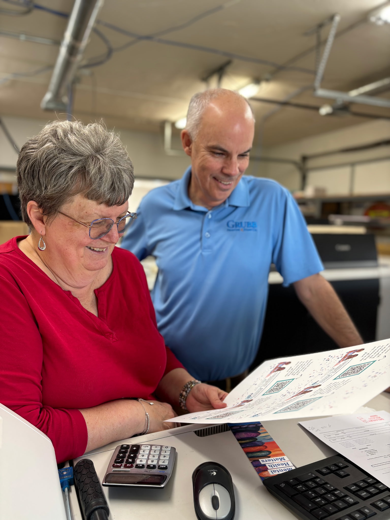 a man and woman looking at a piece of paper