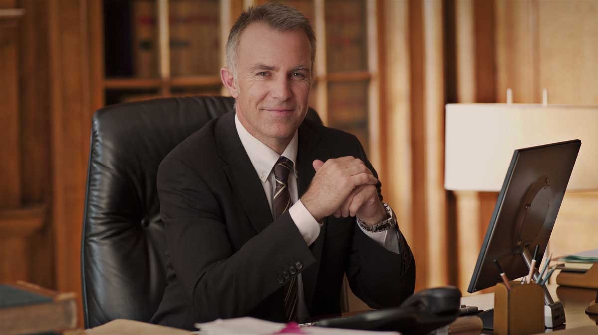 man sitting in office with hands crossed