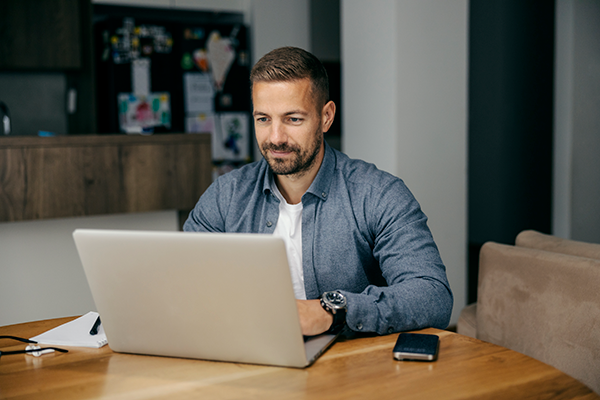man smilling using a laptop