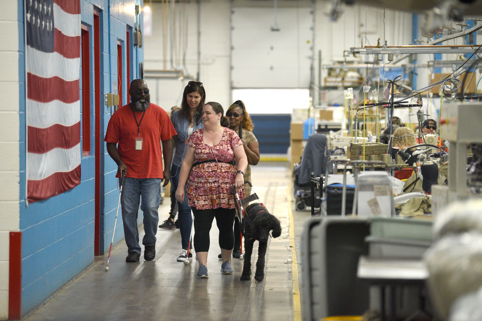 4 people waling with a service dog