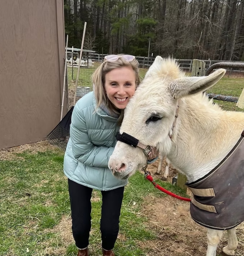 a woman and a horse standing beside each other
