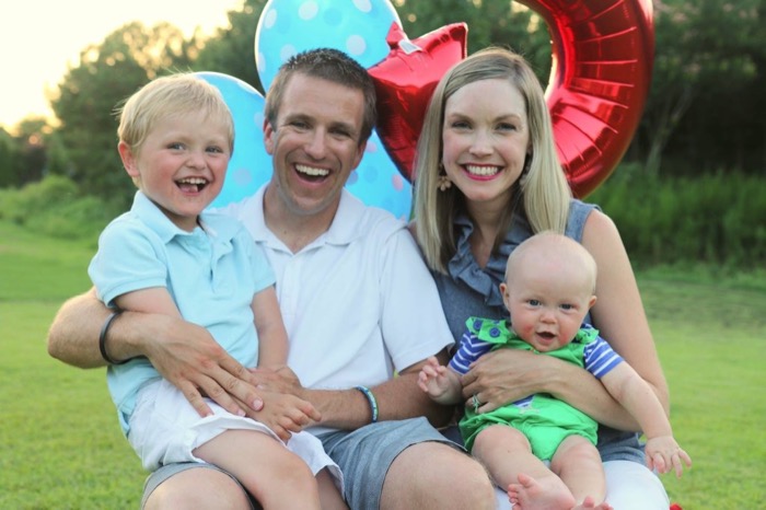 Family photo of two parents with two small children.