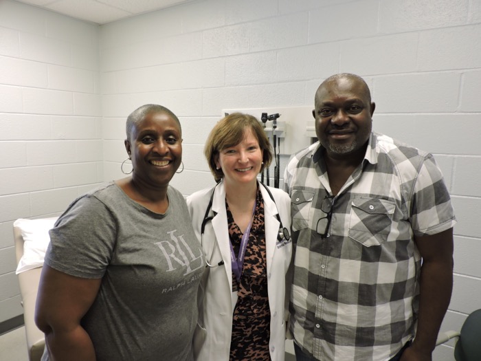 Photo of doctor standing with two people.
