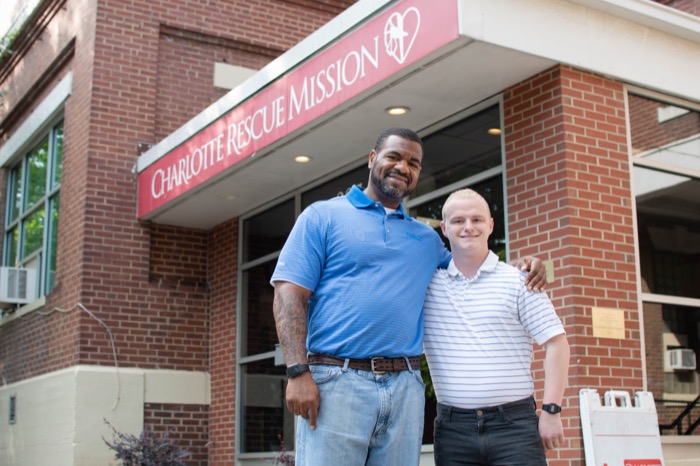 Two men standing in front of rescue mission building.