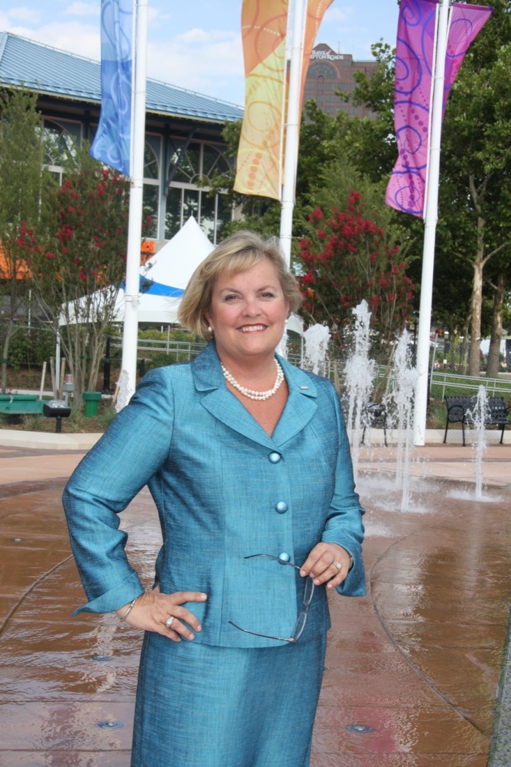 Photo of Ellen Keeter with flags and building in background