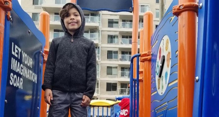 Child standing on outdoor playground equipment