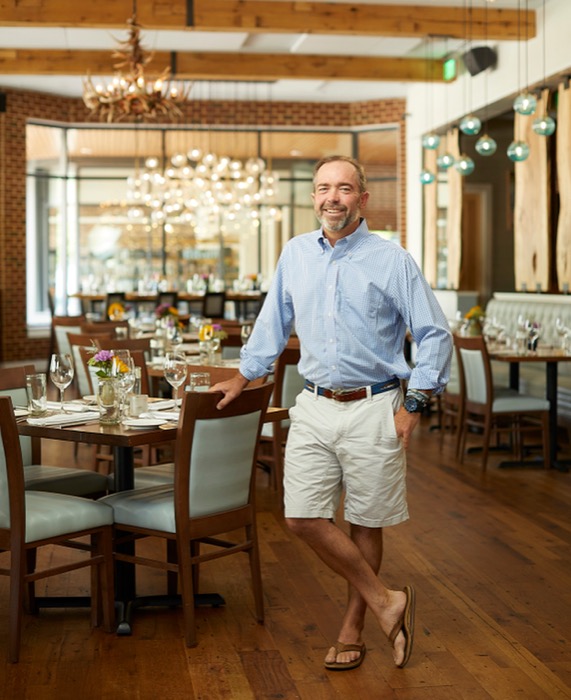 Photo of Chef Walter Bundy standing next to a restaurant table.